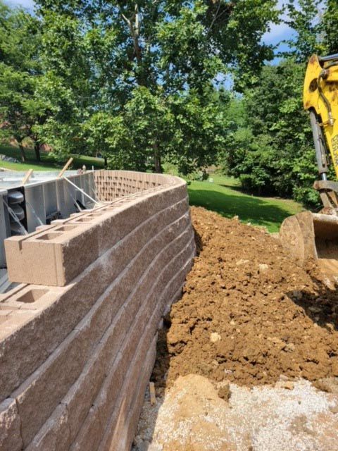 A brick wall is being built next to a pile of dirt.