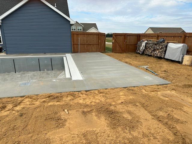 A concrete driveway is being built in front of a house.