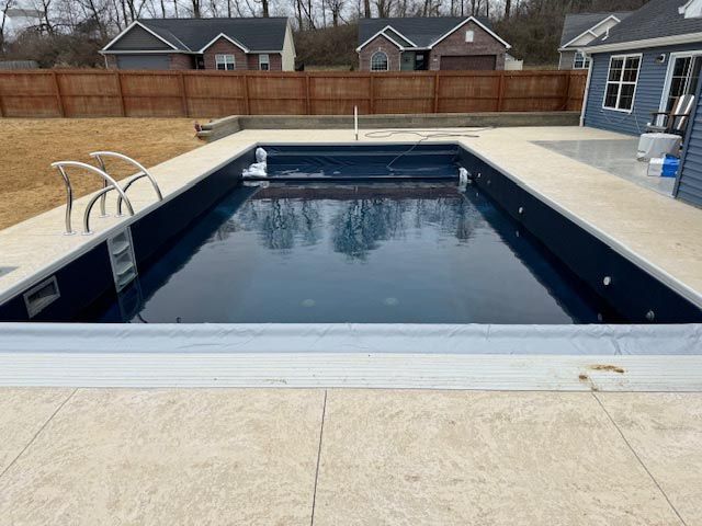 A large swimming pool is sitting in the backyard of a house.