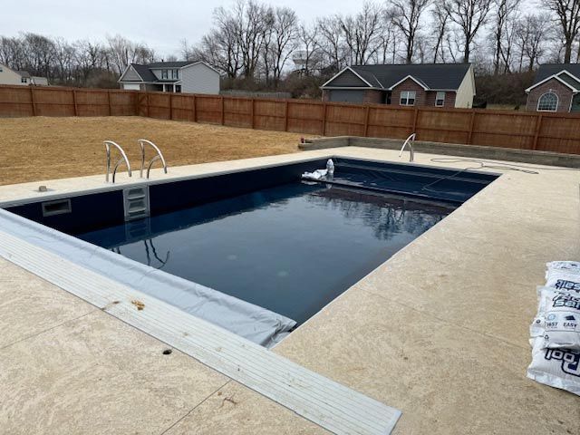 A large swimming pool with a wooden fence surrounding it