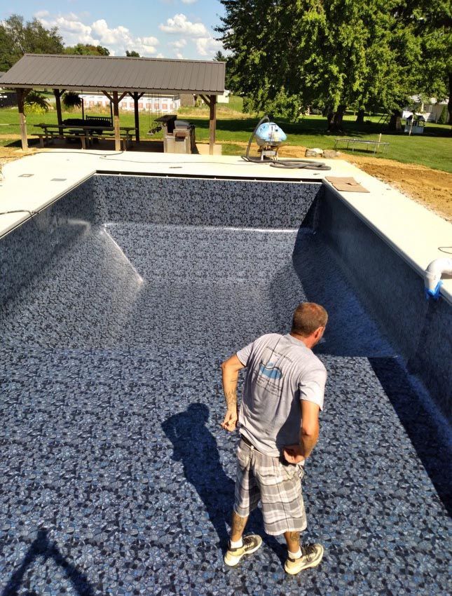 A man is standing in the middle of a swimming pool.