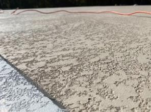 A close up of a concrete surface with a power cord.