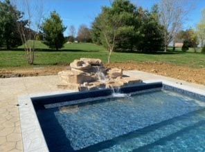 A swimming pool with a waterfall in the middle of it.