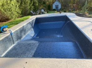 A large swimming pool with a hose attached to the side of it.