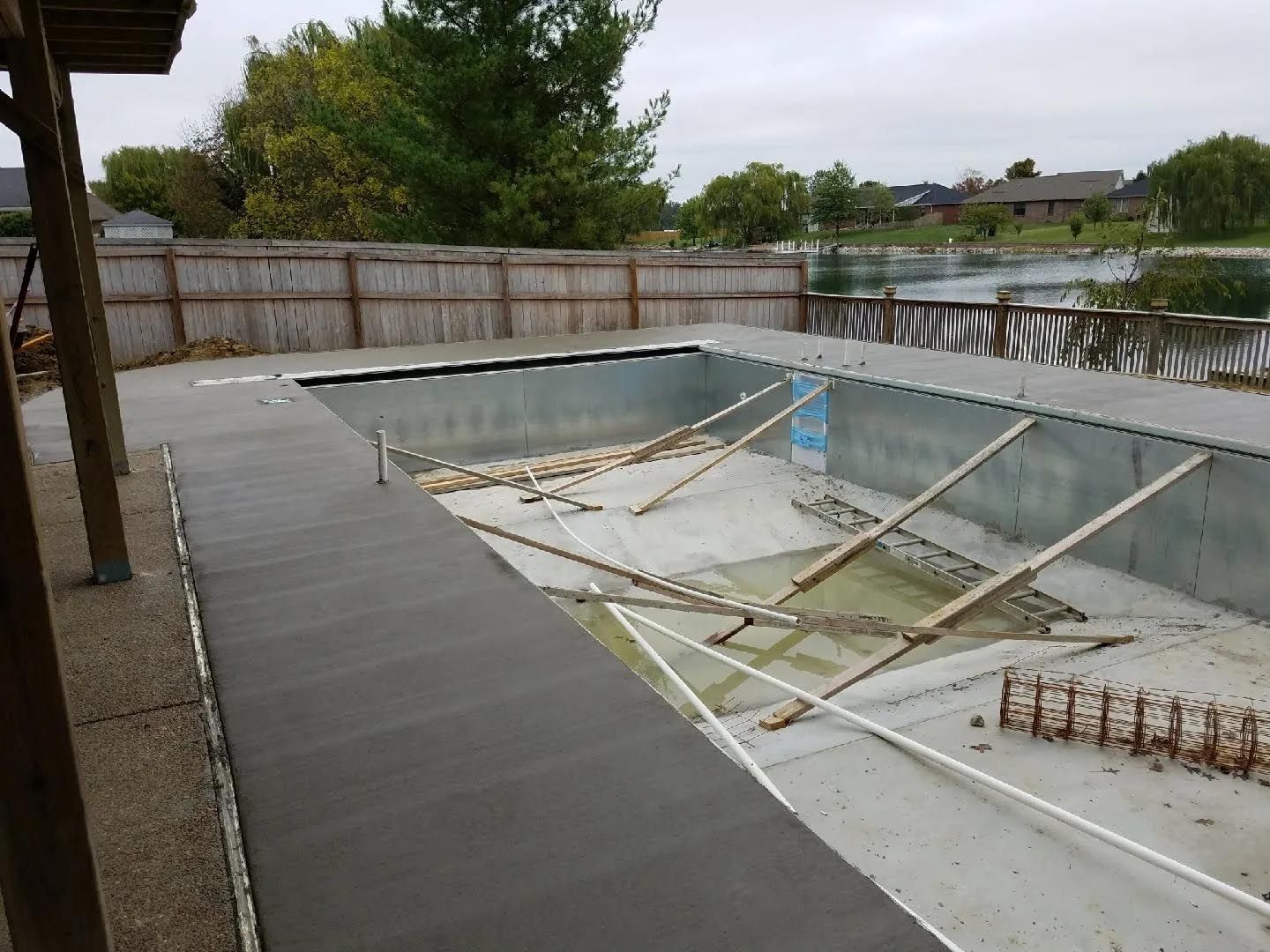 A swimming pool is being built in the backyard of a house