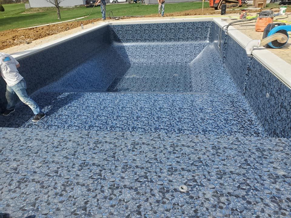 A man is working on the bottom of a swimming pool.