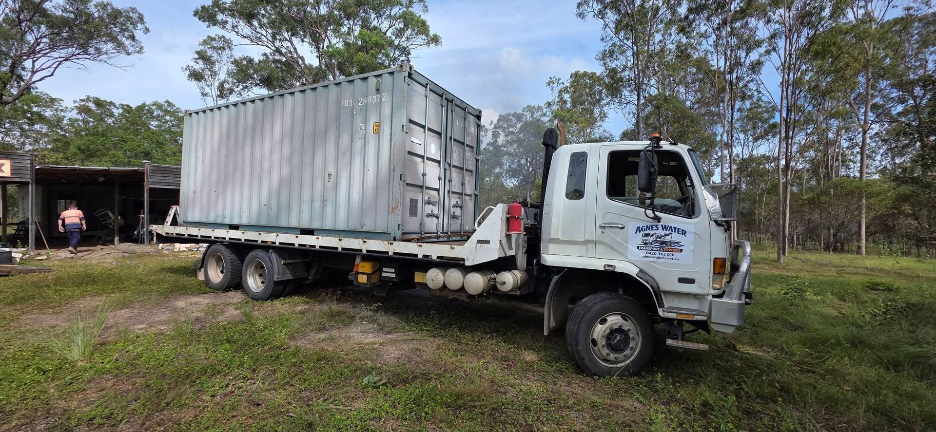 A White Truck Carrying a Large Gray Container — Agnes Water Transport and Towing in Agnes Water, QLD
