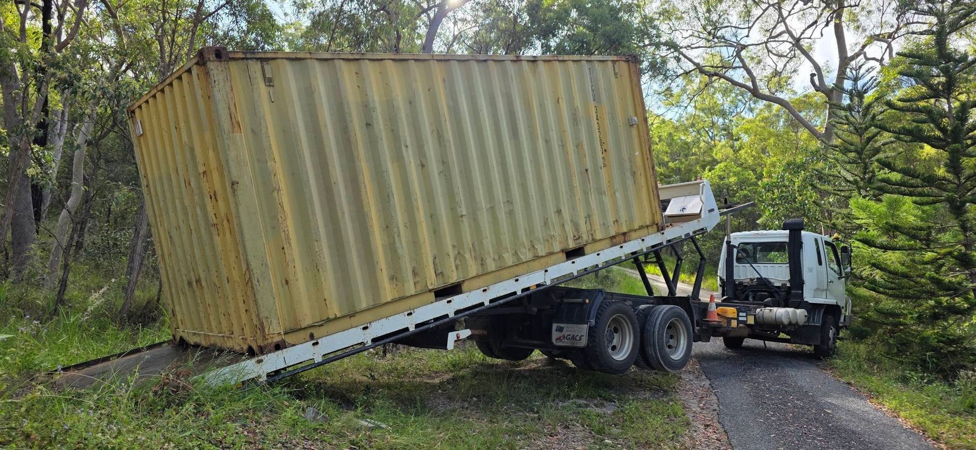 A Yellow Shipping Container Tilted on a Truck — Agnes Water Transport and Towing in Agnes Water, QLD