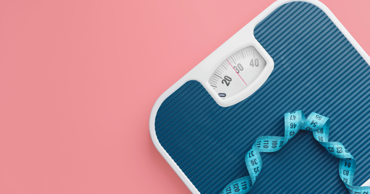 a blue scale and light blue measuring tape on a pink background