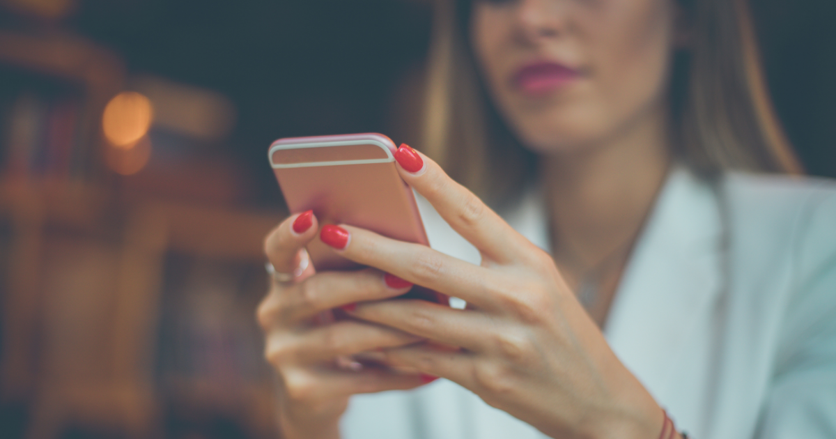 A woman scrolling on her cell phone, looking at news
