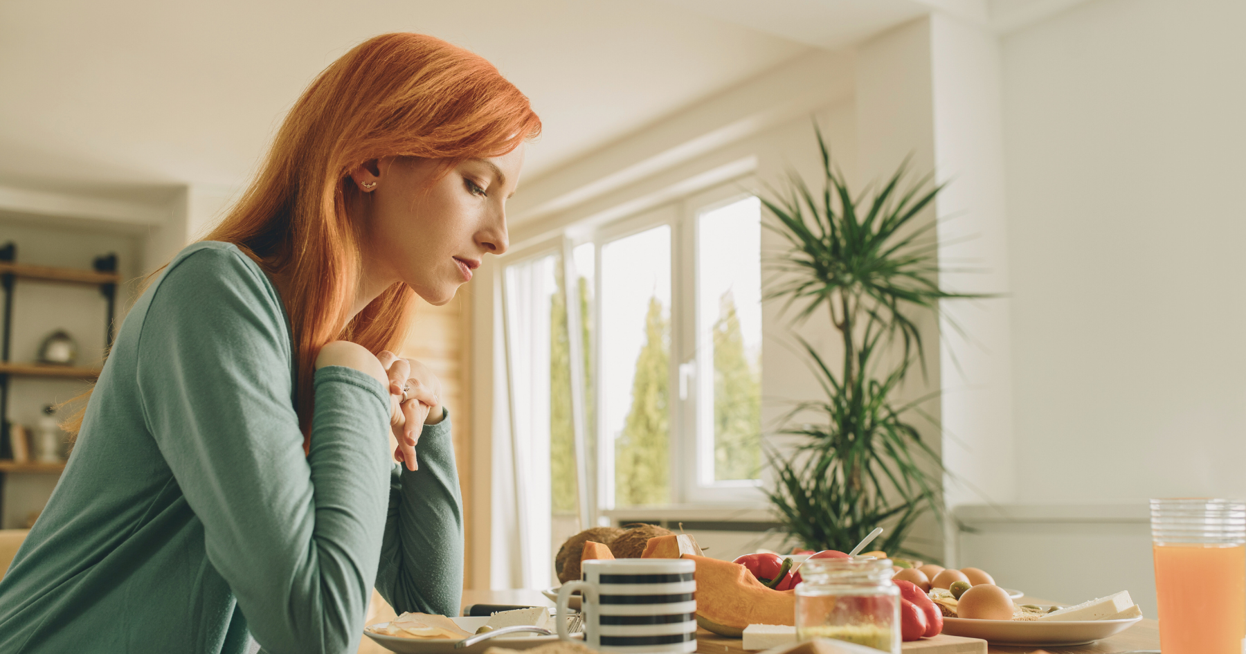 young women with red hair looking at a meal alone - reflecting a highly sensitive struggle