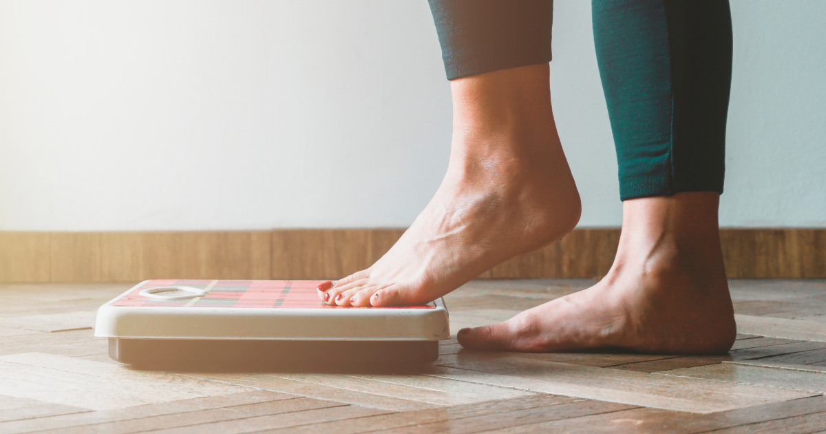 close up of feet stepping on a scale to check weight