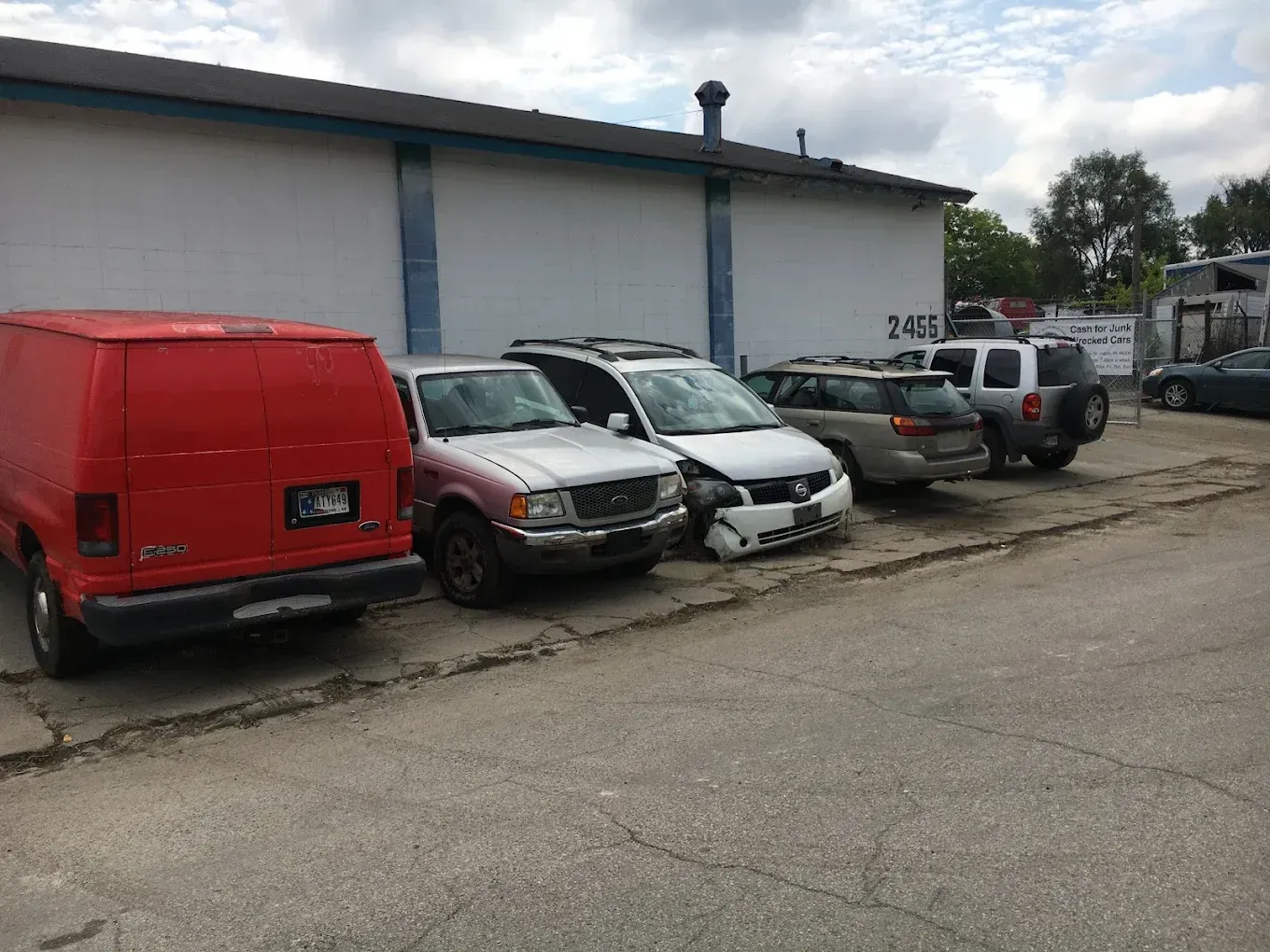A row of cars are parked in front of a building