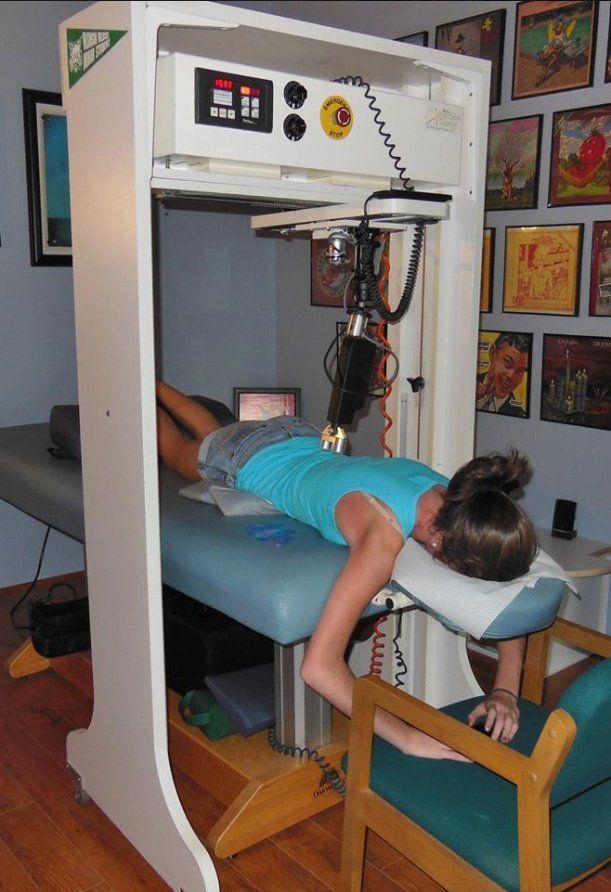 Woman lying on a robotic therapy bed receiving precise, non-invasive lower back treatment. Woman lying on a robotic therapy bed receiving precise, non-invasive lower back treatment.