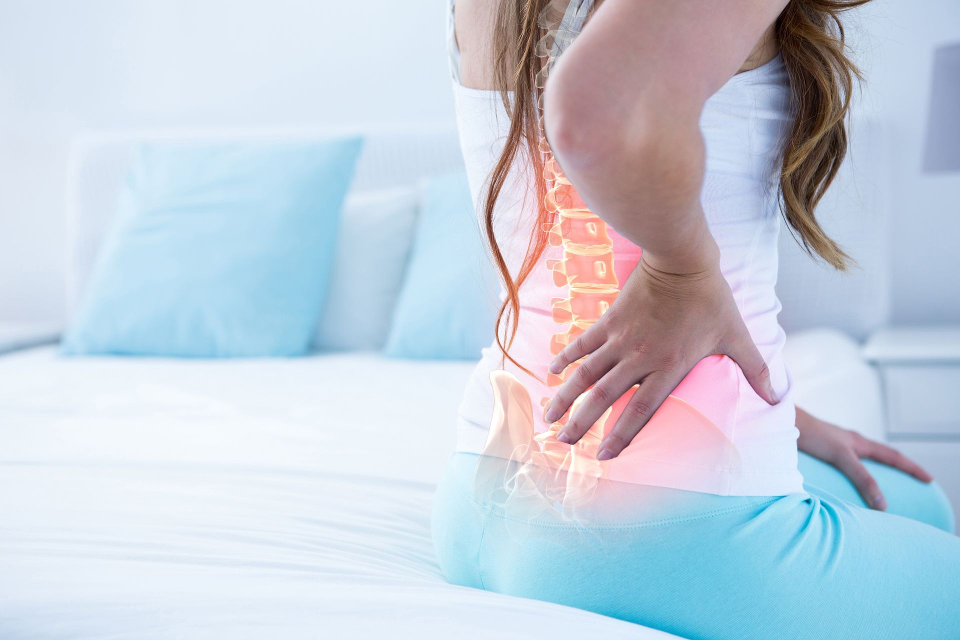 Woman holding her lower back in pain with an illustration highlighting the spine.