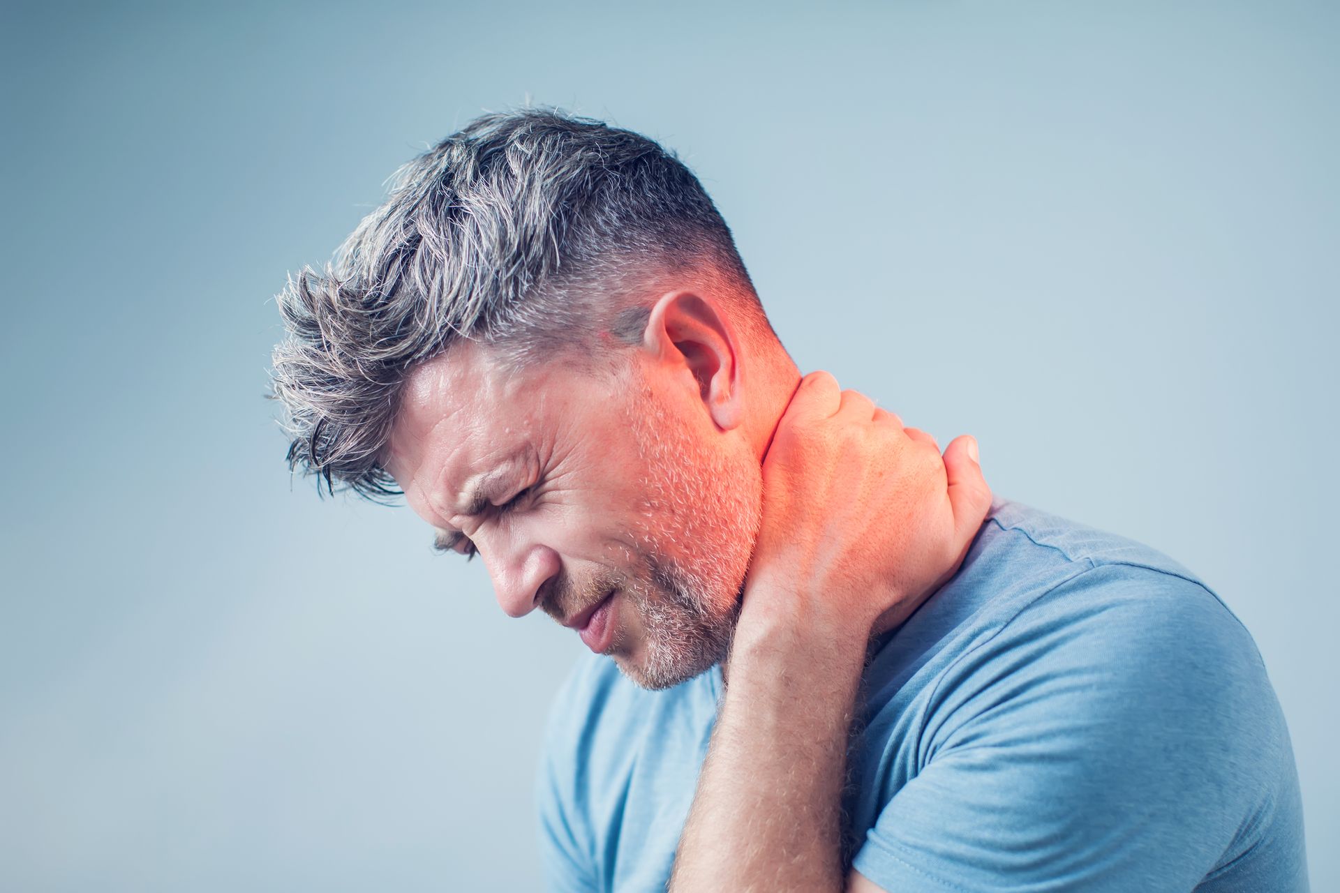 A person holding his neck.