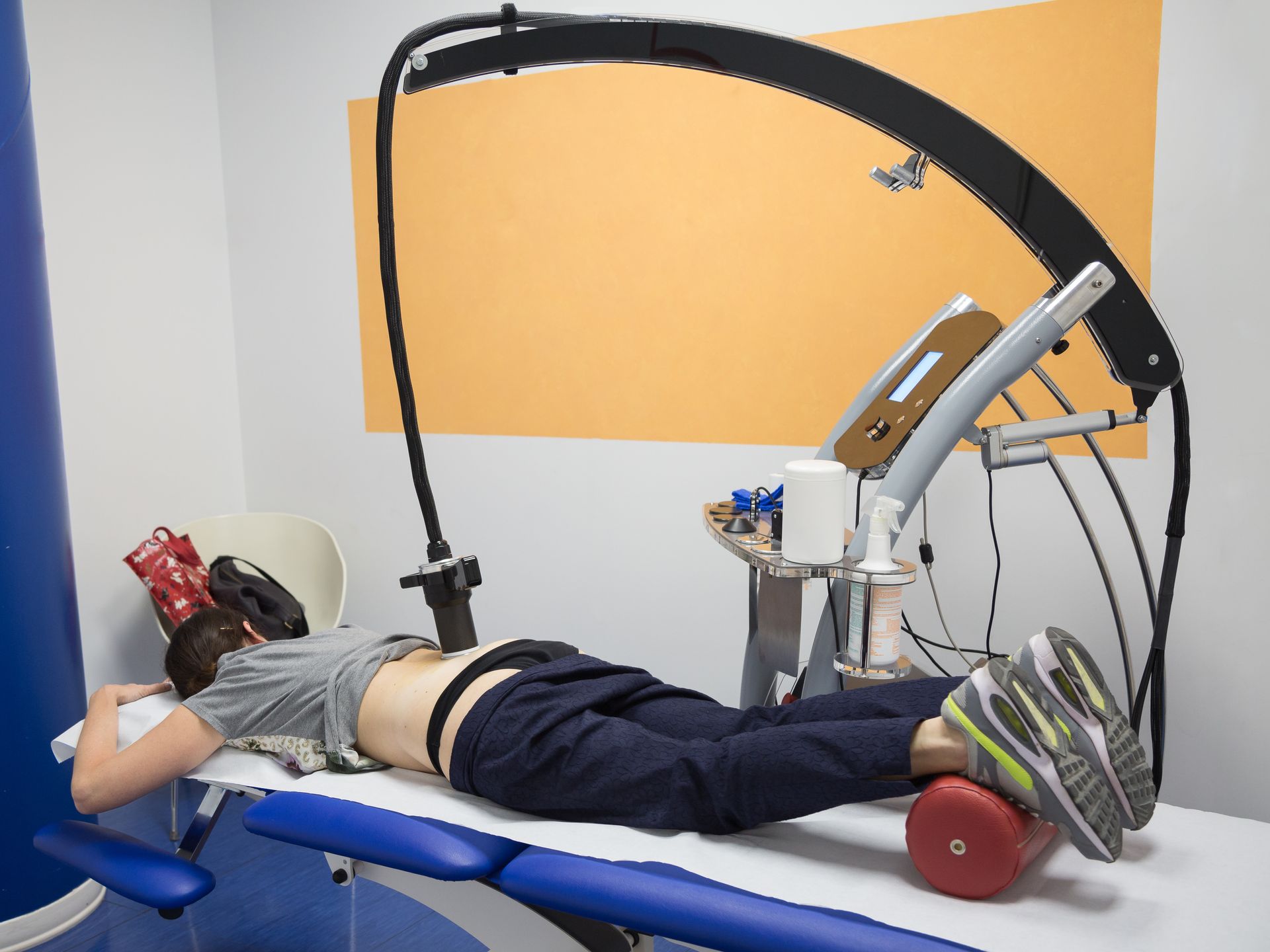 Woman lying on a bed undergoing robotic therapy.