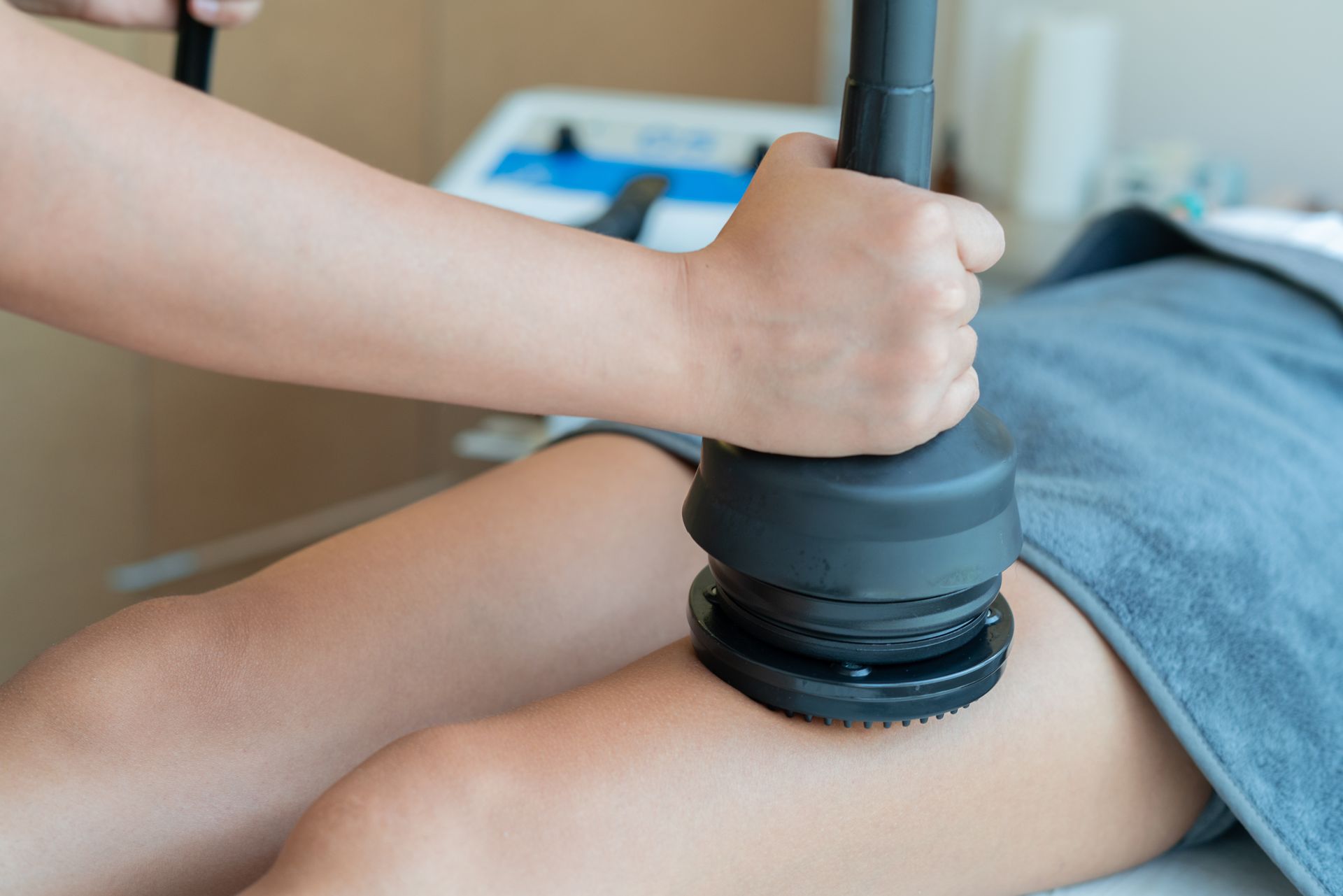 Person receiving leg massage with a handheld device in a spa setting.