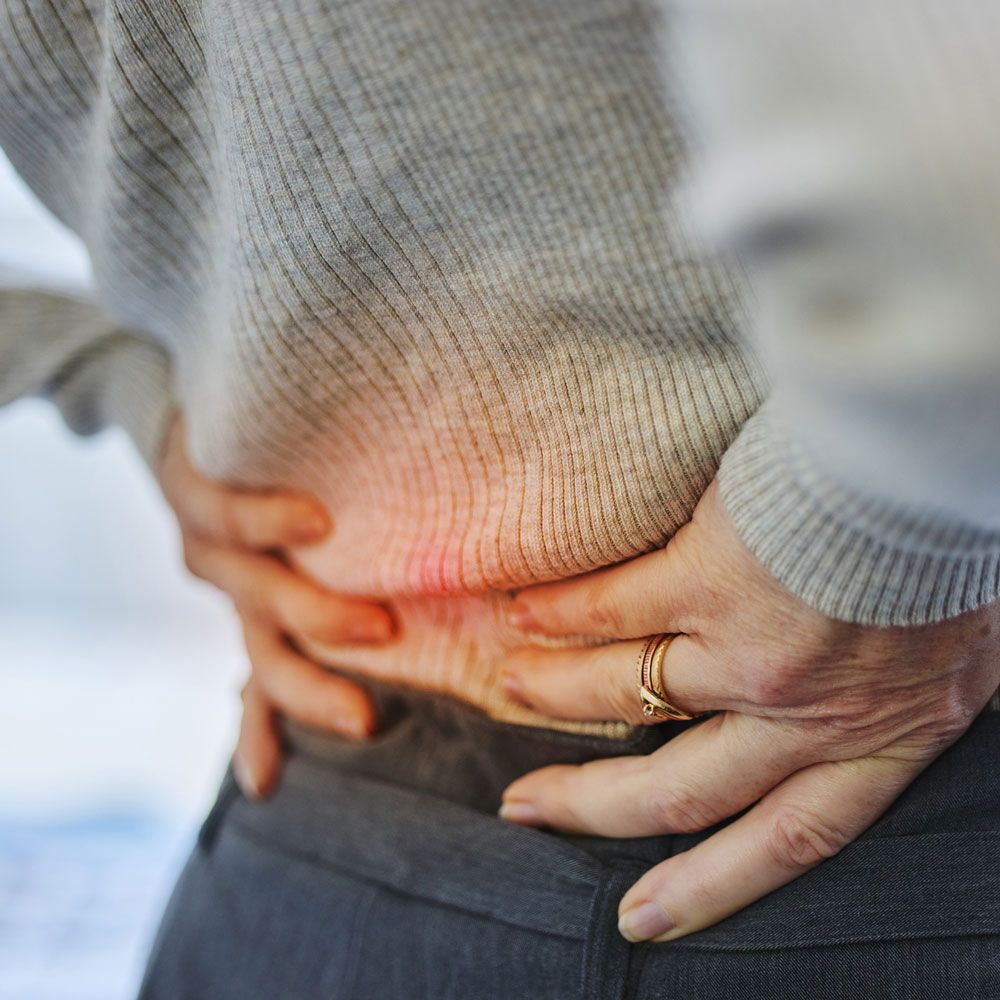 A person is holding their stomach in pain.