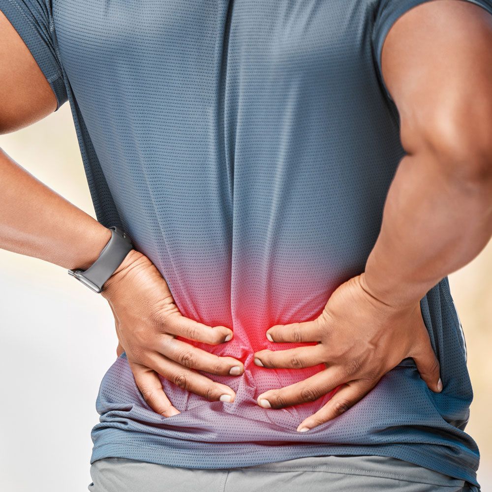 A man is holding his back in pain.