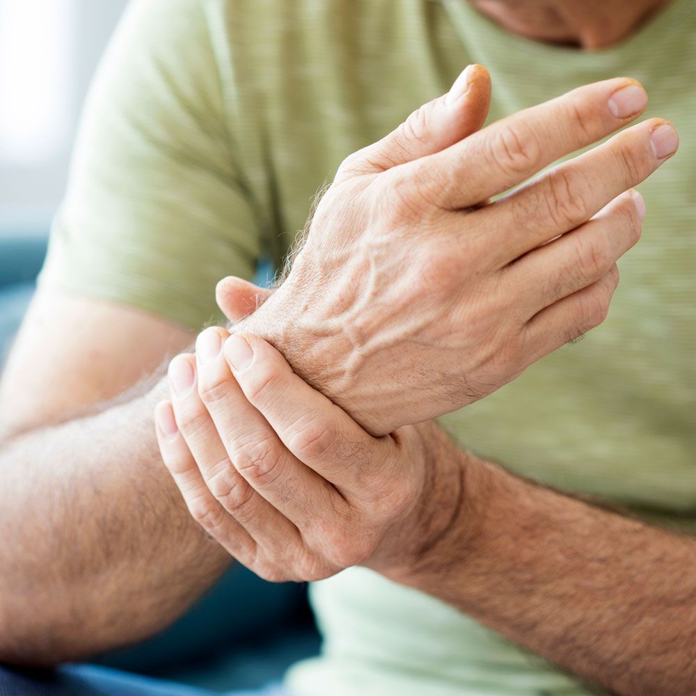 A man is holding his wrist in pain.