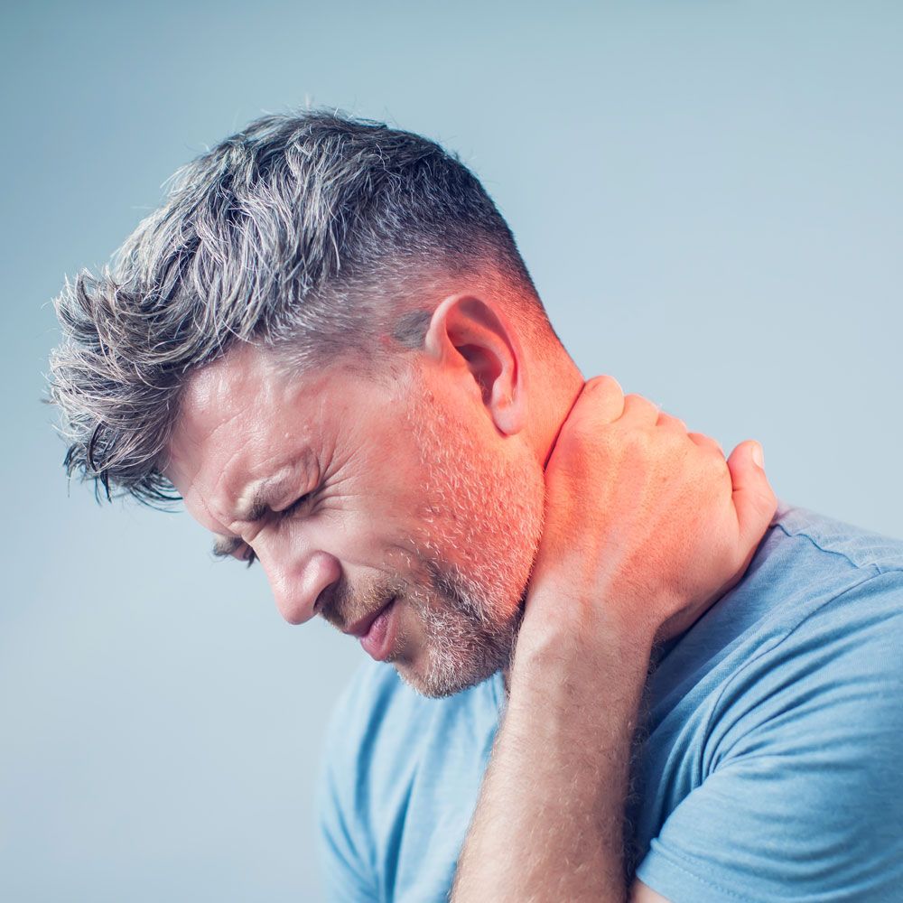 A man is holding his neck in pain.
