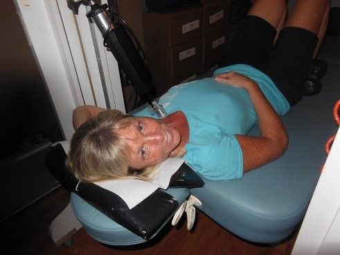 Blonde woman lying comfortably while receiving advanced robotic neck therapy in Sarasota.