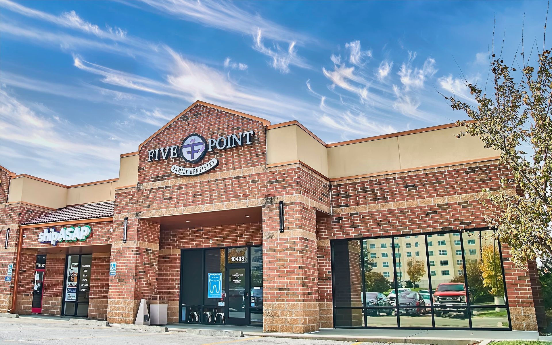 Exterior of Five Point Family Dentistry with brick facade, under cloudy sky.