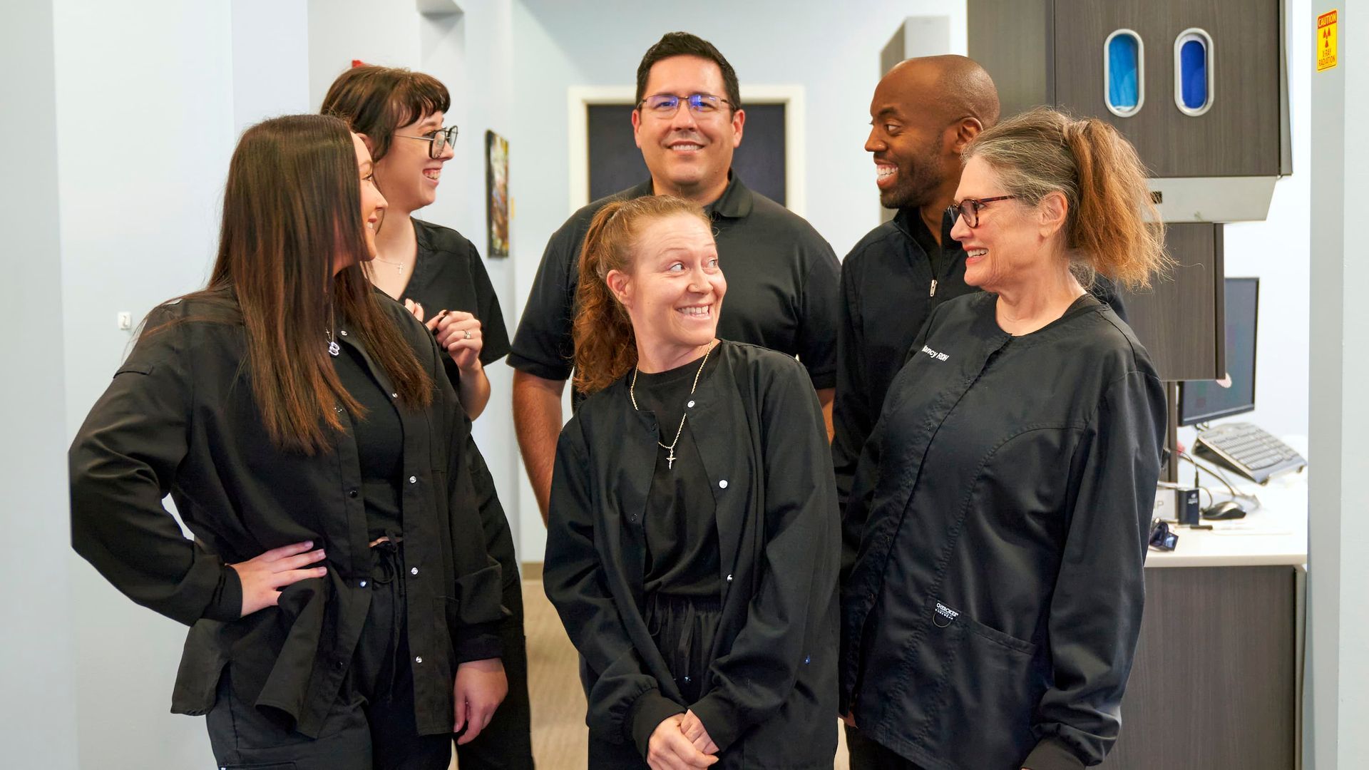 Dentist examining a patient's mouth in a dental office. The patient is sitting in a chair.