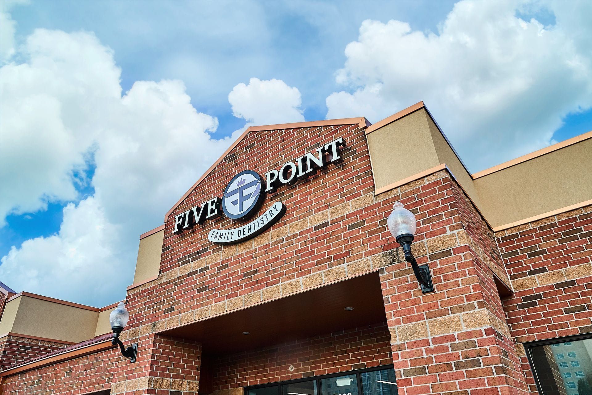 A brick building with a sign that says Five Point Family Dentistry on it.