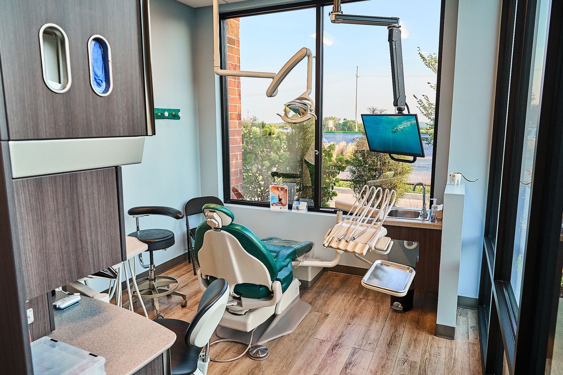 A dental office with a dental chair and a window.