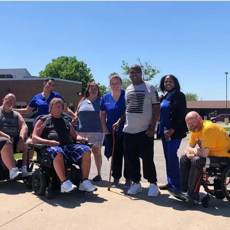 A group of people posing for a picture including a man wearing a shirt that says champions