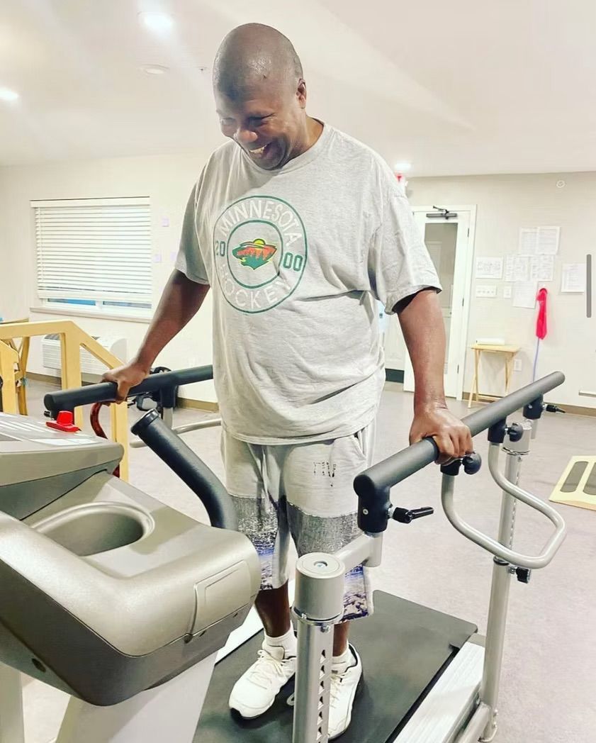 A man is standing on a treadmill in a gym.