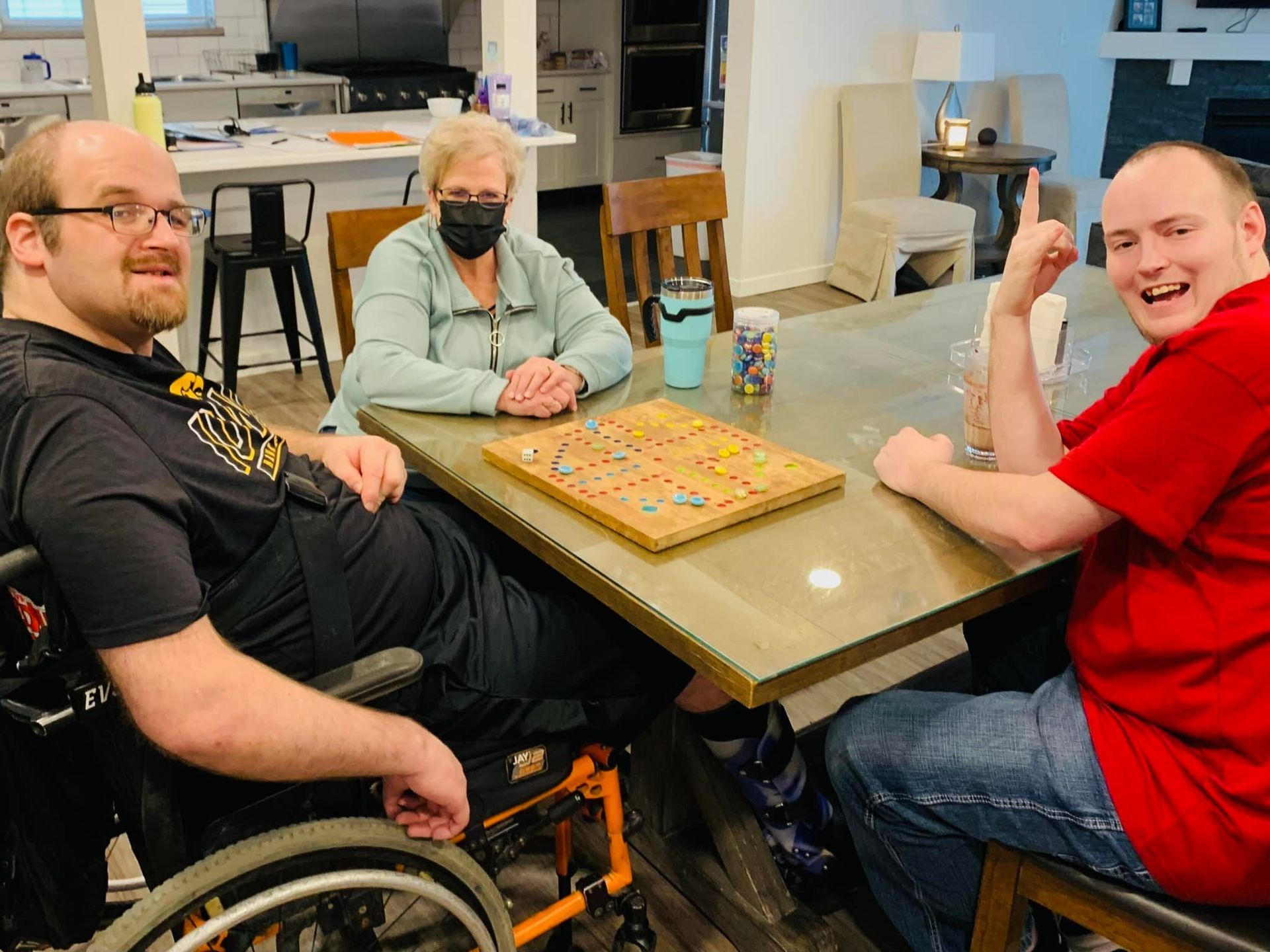 A group of people are sitting at a table playing scrabble.