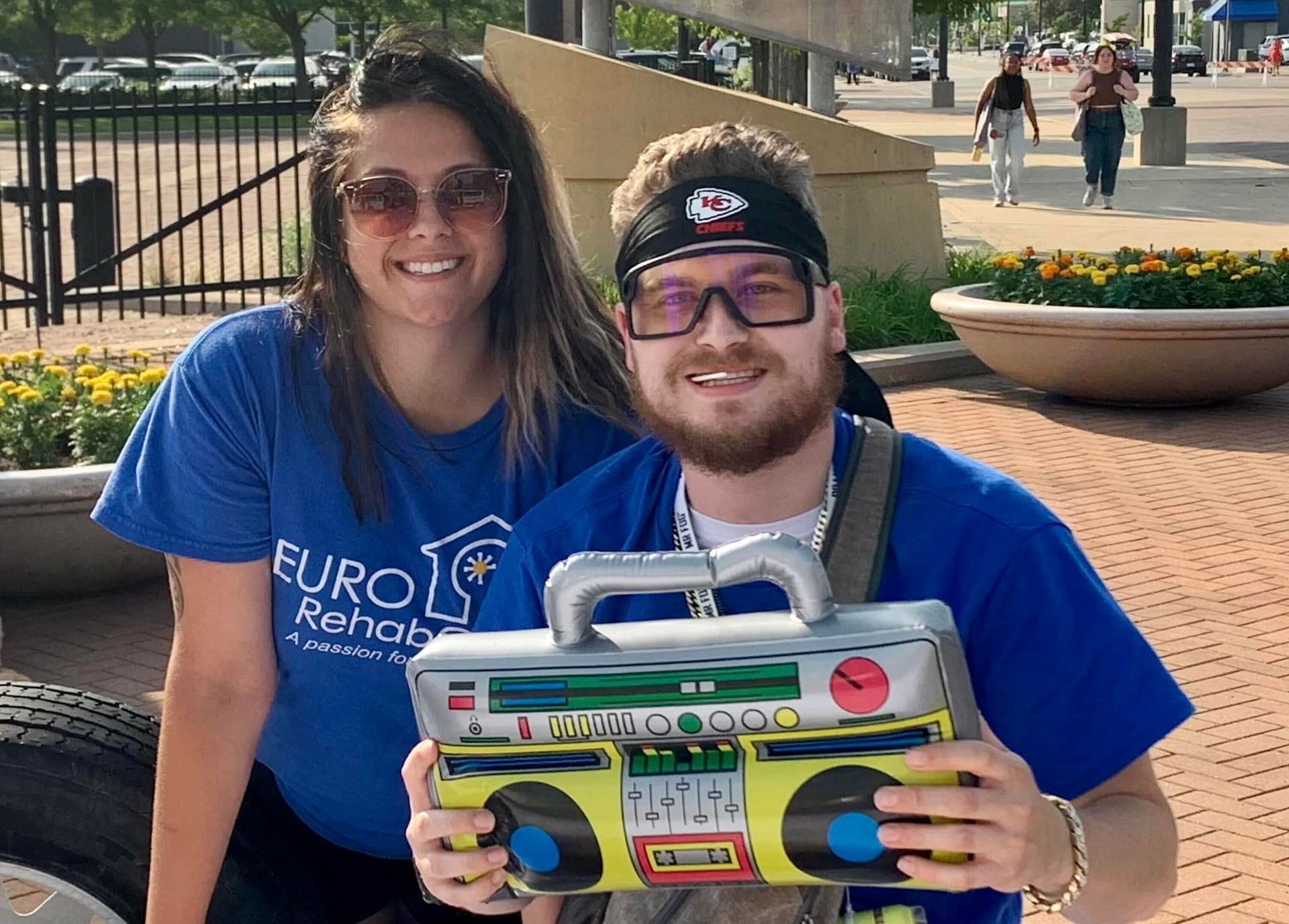 A man and a woman are posing for a picture while holding a boombox.