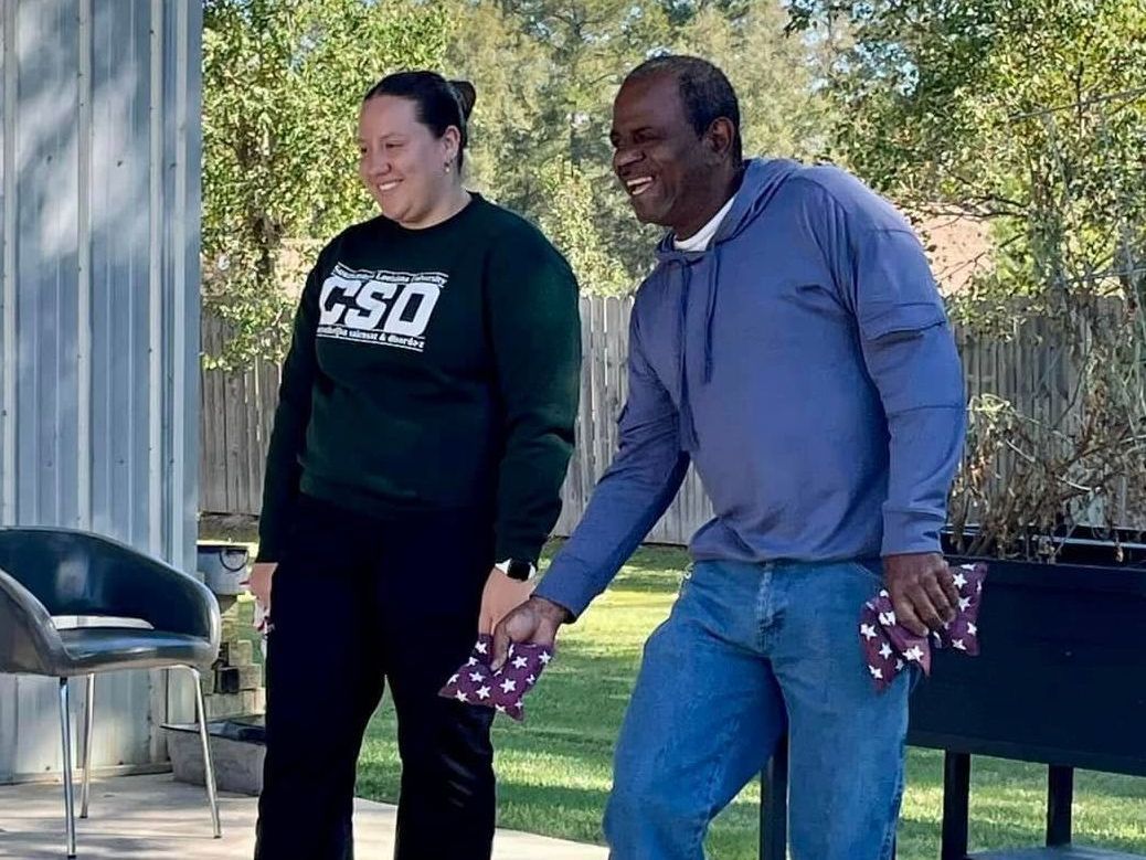 A man and a woman are standing next to each other holding hands.