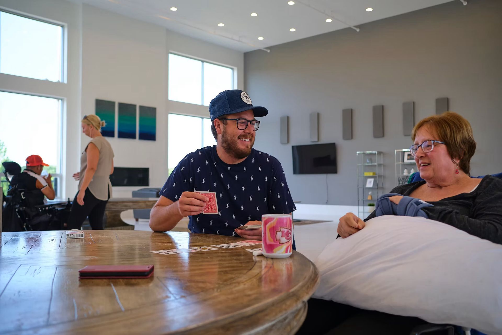 A man and a woman are sitting at a table playing cards.