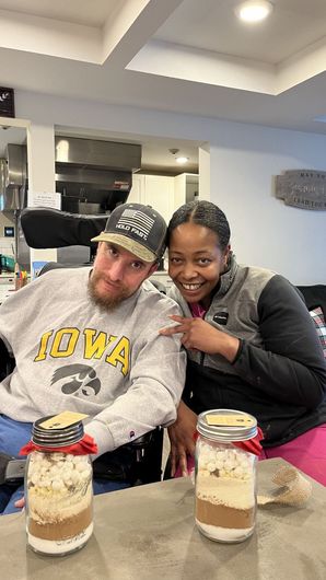 A man and a woman are sitting at a table with jars of food.