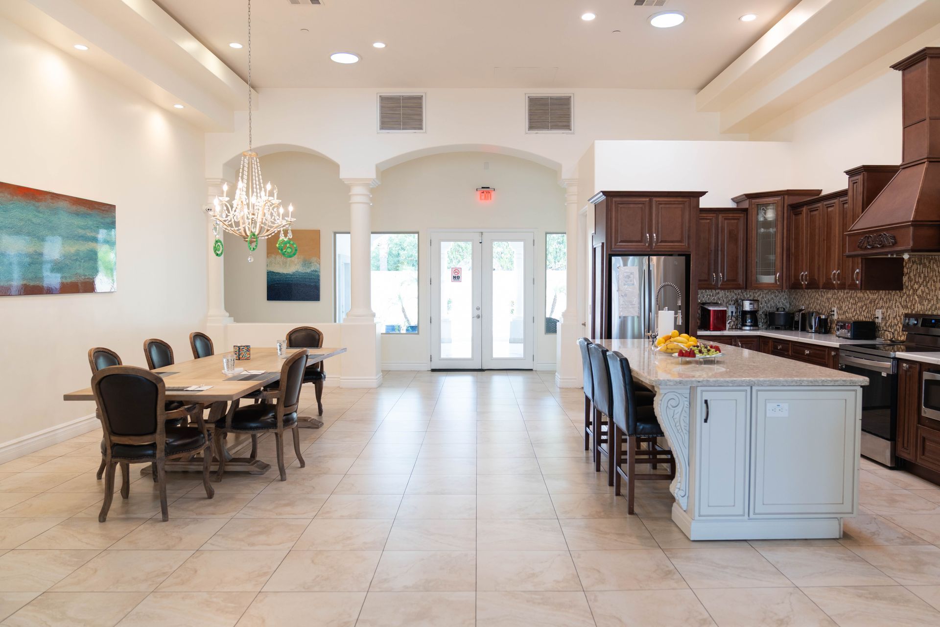 A large room with a dining table and chairs and a kitchen.