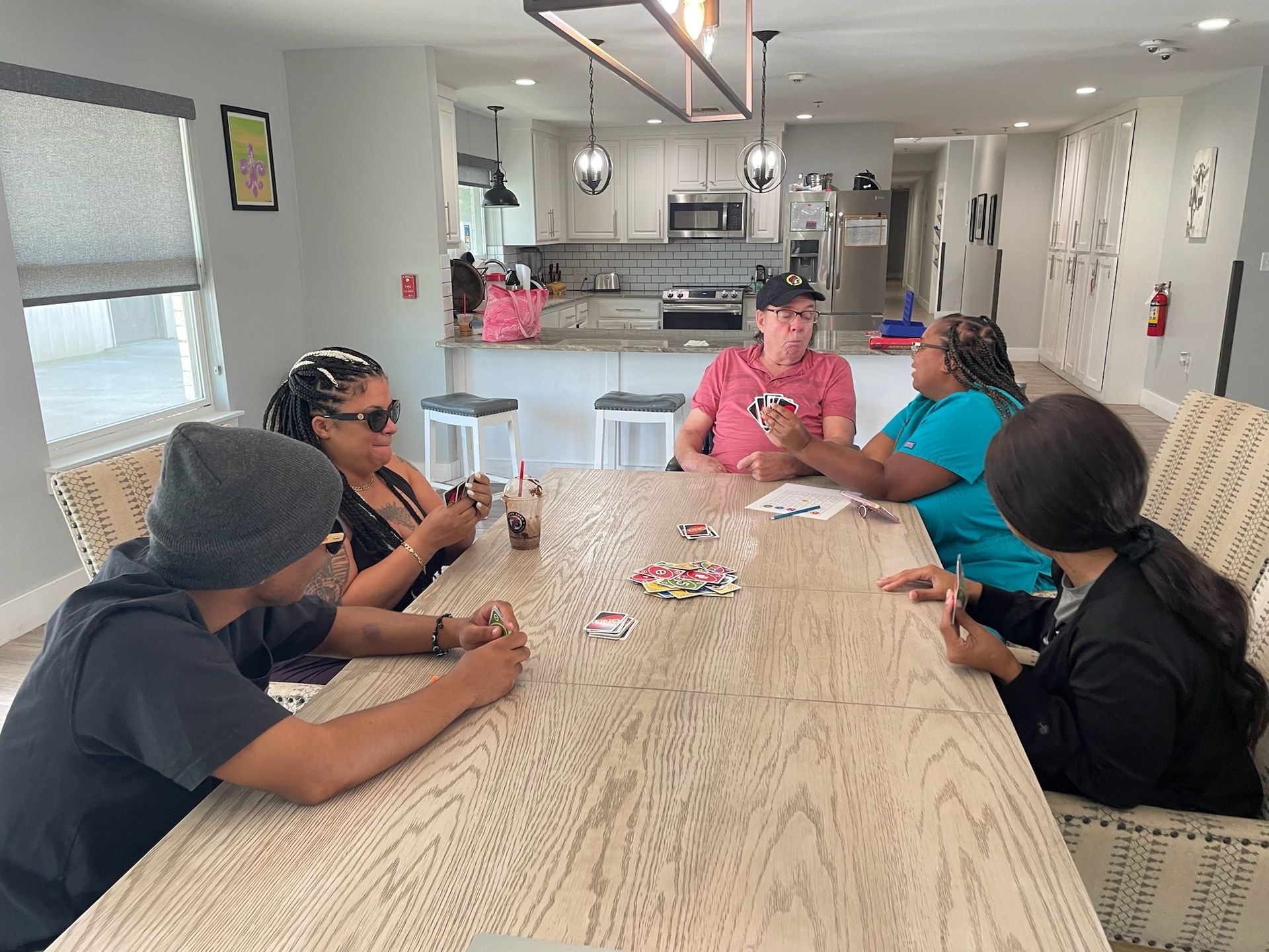 A group of people are sitting around a table playing cards.