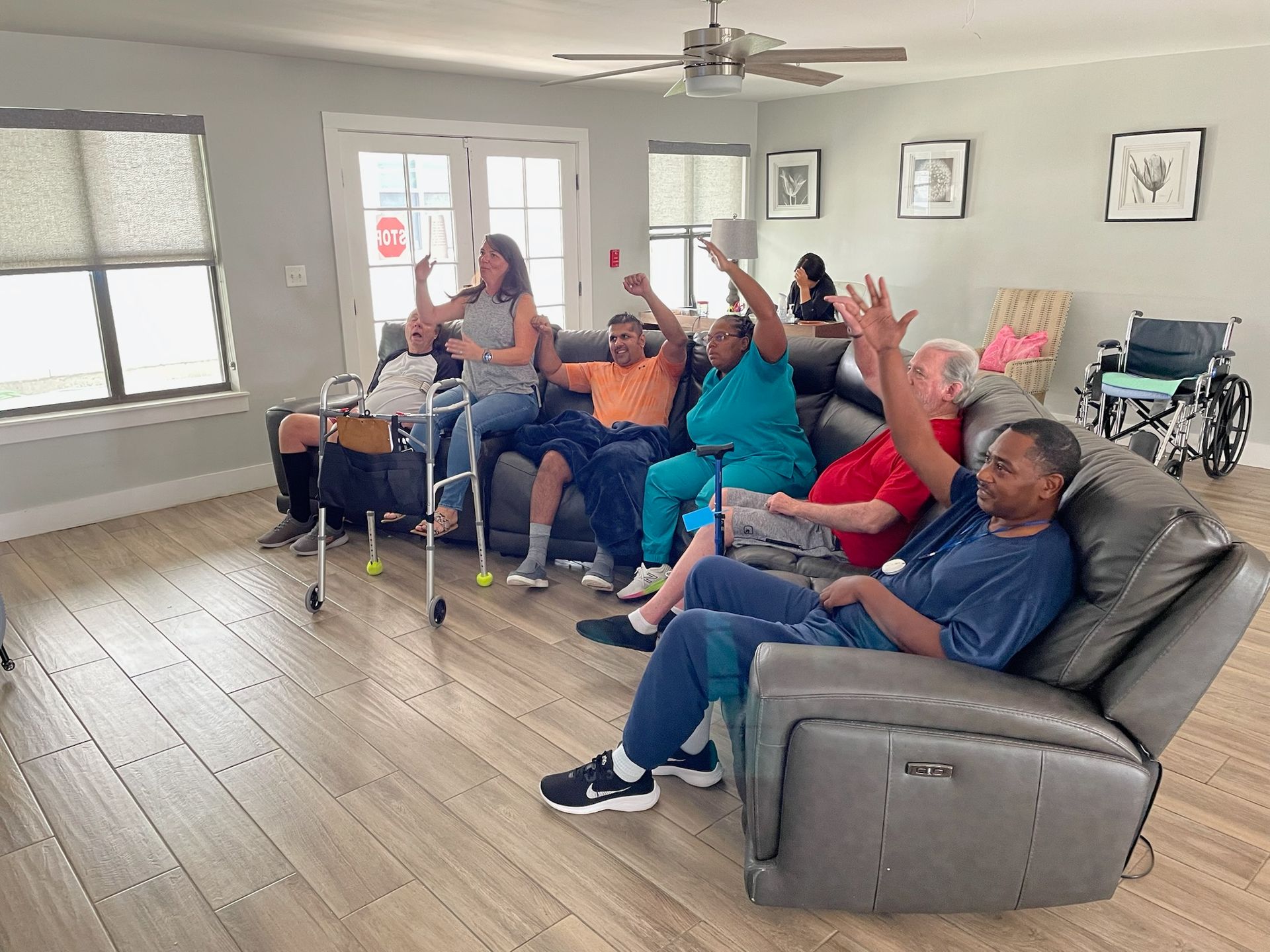 A group of people are sitting in chairs in a living room.