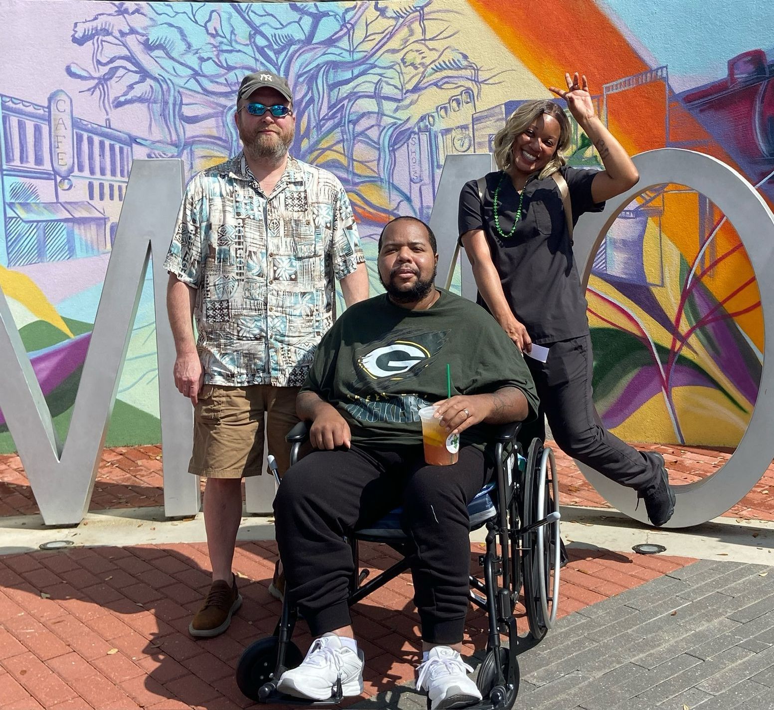 A man in a green bay packers shirt is sitting in a wheelchair