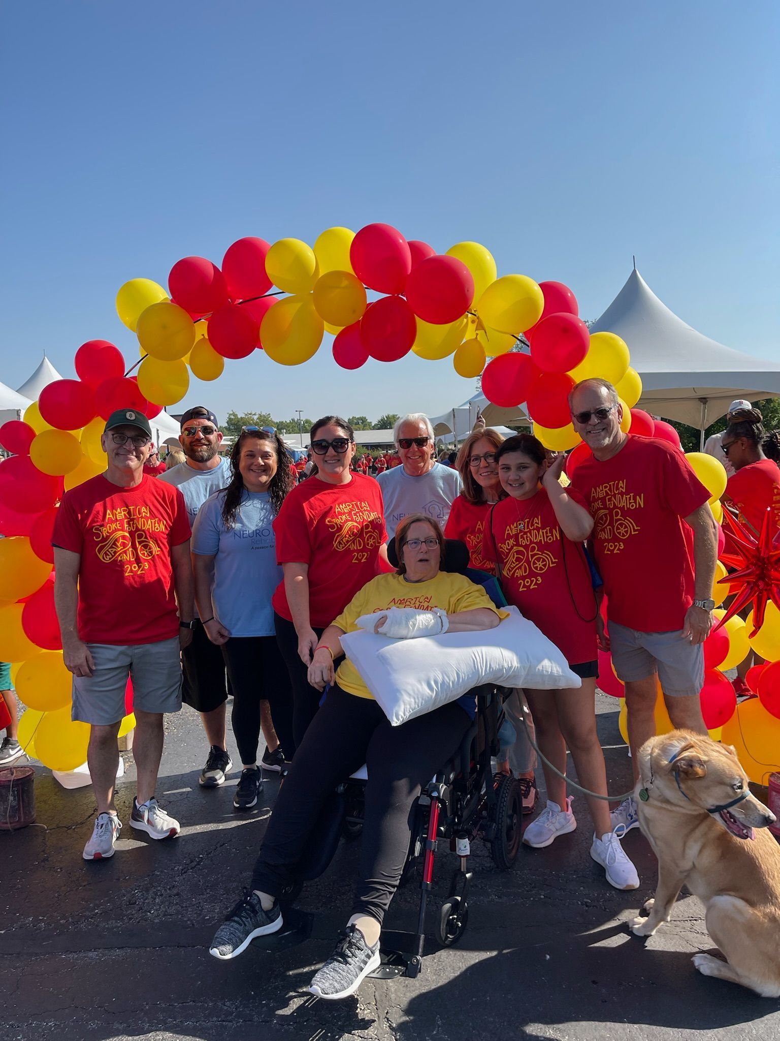 A group of people are posing for a picture with balloons in the background.
