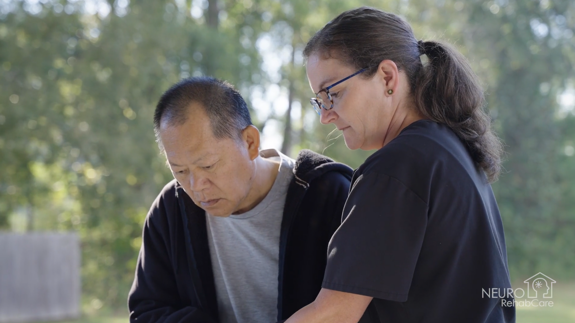 A man and a woman are looking at a tablet together.