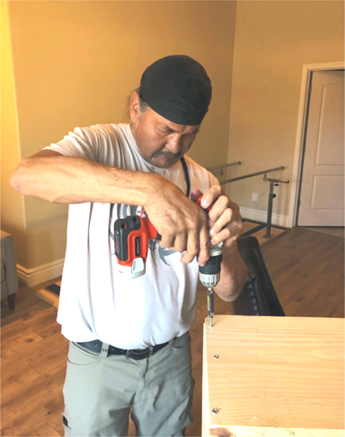 A man is working on a piece of wood with a drill