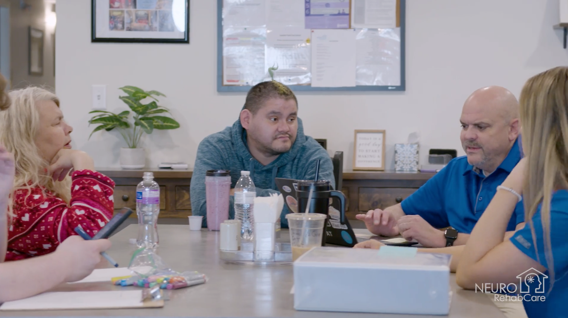 A man with a beard and a woman wearing sunglasses are sitting next to each other.