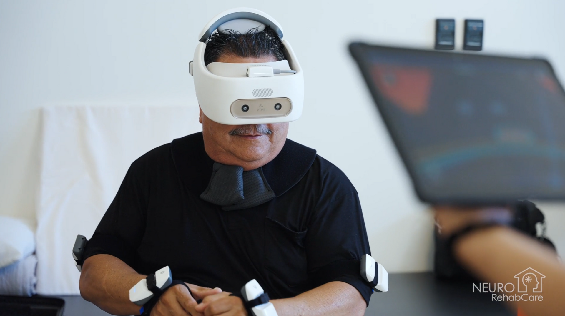 A man wearing a virtual reality headset is sitting at a table.