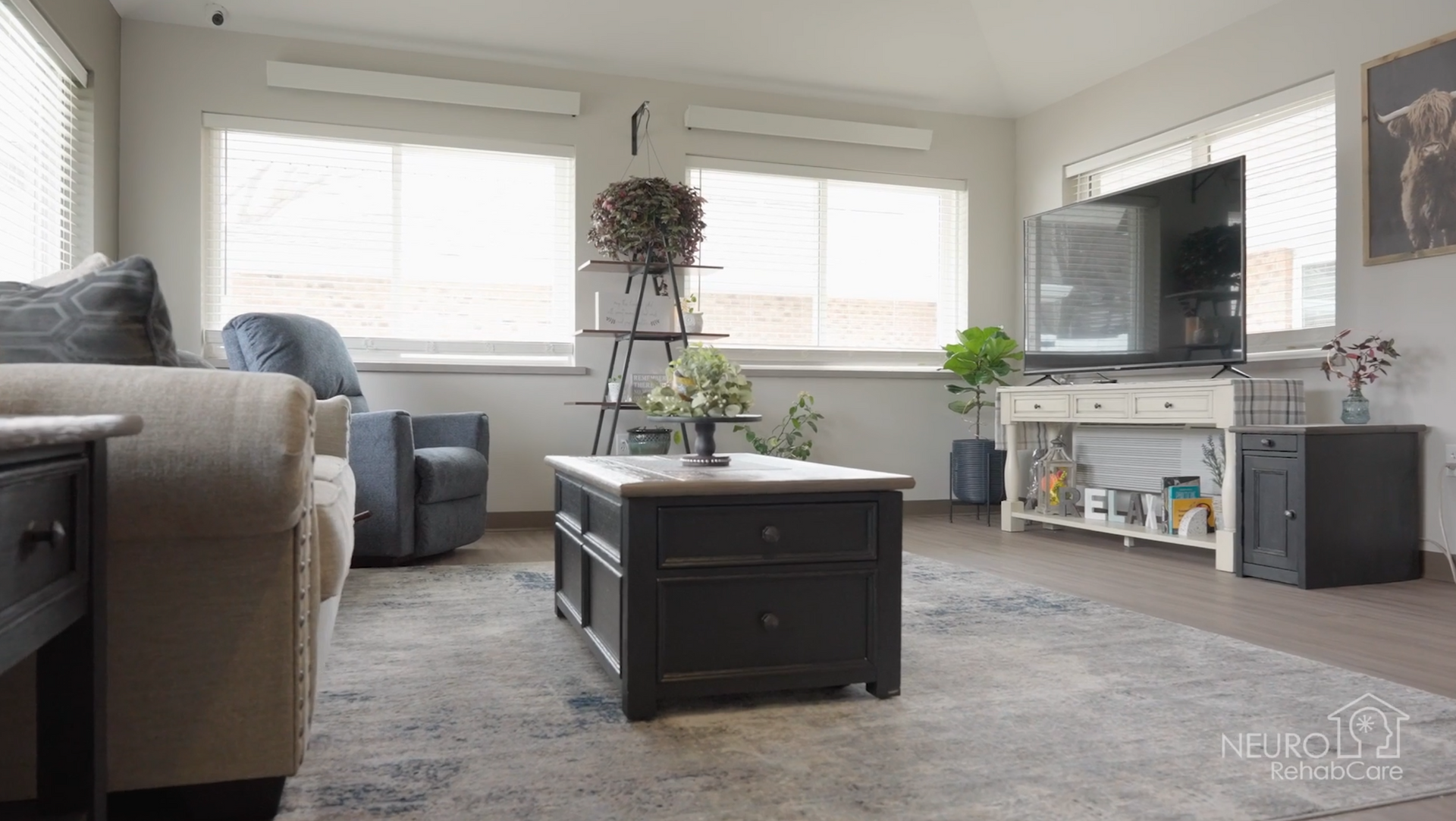 A living room with a couch , chair , coffee table and television.