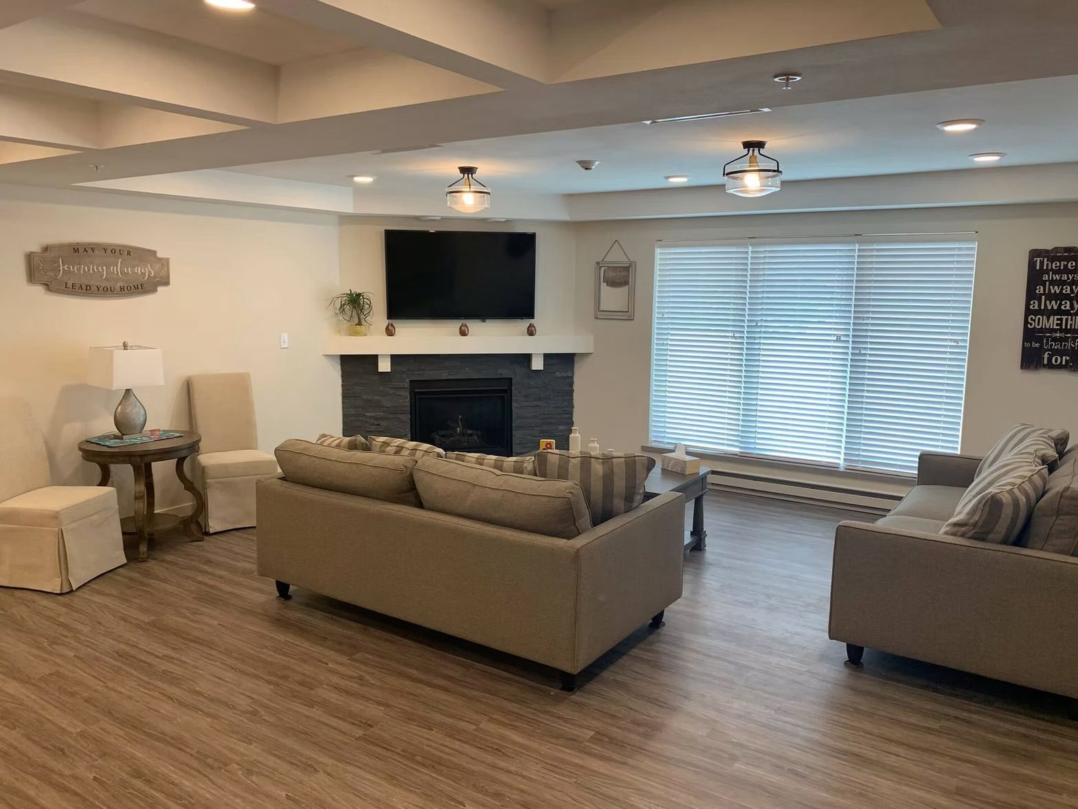 A living room with two couches , a fireplace , and a flat screen tv.