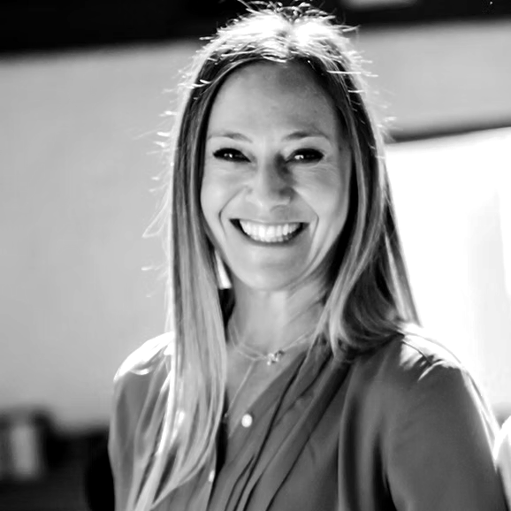 A woman is smiling in a black and white photo.